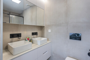 Modern bathroom with twin sinks and stone walls
