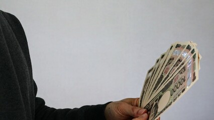 大量の一万円札を持つ人物