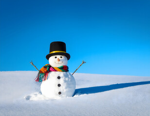 Fototapeta premium Snowman with a hat and scarf in a snowy landscape under a clear blue sky