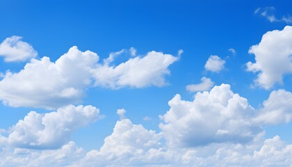 Clear blue sky filled with soft, fluffy white clouds floating gently, creating a bright and peaceful atmosphere on a sunny day with natural daylight