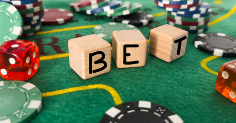 Letters bet and poker chips next to dice 