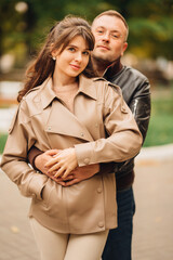 Fototapeta premium Couple enjoying a romantic moment in a park during autumn afternoon