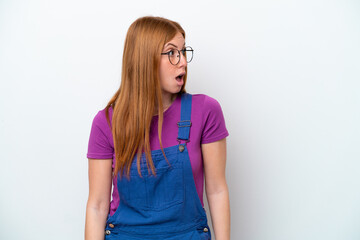 Young redhead woman isolated on white background doing surprise gesture while looking to the side