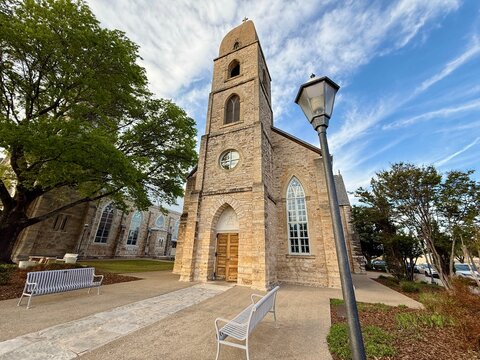 Old Saint Mary Church with arched windows and a tall bell tower under a blue sky