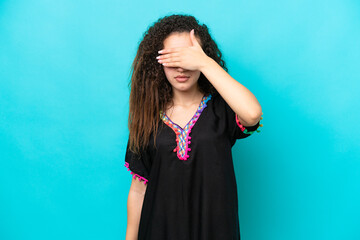 Young Arab woman isolated on blue background covering eyes by hands. Do not want to see something