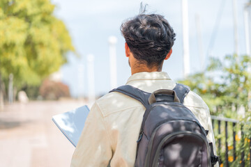 Young student Arabian man at outdoors in back position