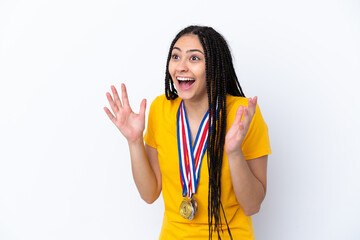 Teenager girl with braids and medals over isolated pink background with surprise facial expression