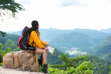 Woman travel  hiker adventure relax after walking on mountain nature landscape.  Asia people lifestyle tourist girl backpack sitting with map to find directions explore and camping outdoors.