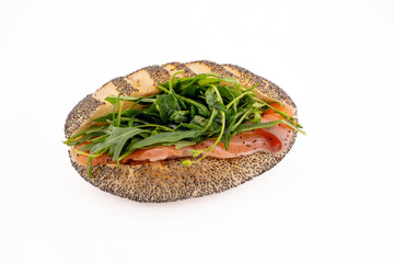 A single, appetizing smoked salmon sandwich is presented on a plain white plate.