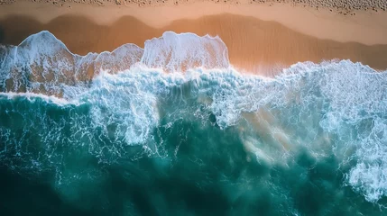 Selbstklebende Fototapeten Aerial view of waves crashing on a sandy beach creating white foam and turquoise water near the shore © Mitchell