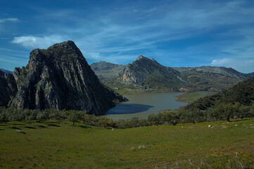 Zahara de la sierra reservoir surrounded by mountains reflecting on the water in andalusia, spain