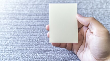 Obraz premium Hand holding blank invitation card on textured background promote your event or design with this elegant mockup featuring space for message 
