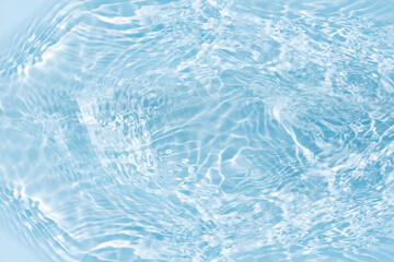 Blue water with ripples on the surface. Defocus blurred transparent blue colored clear calm water surface texture with splashes and bubbles. Water waves with shining pattern texture background.