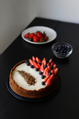 freshly baked classic cheesecake with strawberries and blueberries