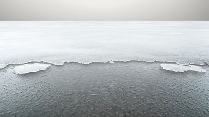 Grey ice sheet stretches with a thin layer of meltwater, against a simple grey background