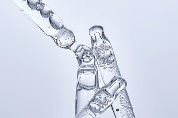 Four different face serum pipettes on a neutral background.