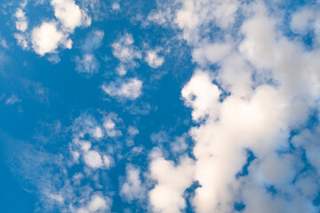 Clear Blue Sky with Scattered White Clouds in Daylight. The fluffy clouds appear in varying shapes and sizes, enhancing the serene beauty of a sunny day. High quality photography