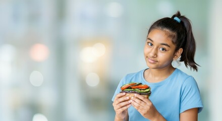 Naklejka premium Asian young female enjoying a healthy sandwich with vegetables in a casual setting