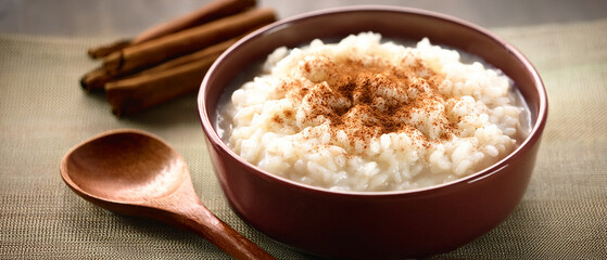 Healthy breakfast with a cup of coffee, sugar, and cinnamon served alongside a fresh bowl of rice, curd, cheese, and oatmeal on a white plate