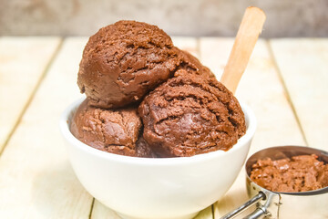 chocolate scoop ice cream in a bowl on a wooden table