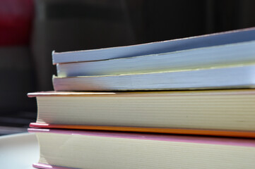 colorful stack hardcover books detailed textures pages natural light modern feel bookstore library...
