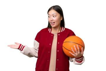 Young basketball player asian woman over isolated background with surprise expression while looking side