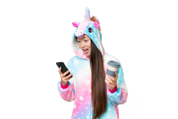 Young Asian woman with unicorn pajamas over isolated chroma key background holding coffee to take away and a mobile