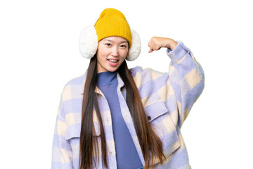 Young Asian woman wearing winter muffs over isolated chroma key background doing strong gesture