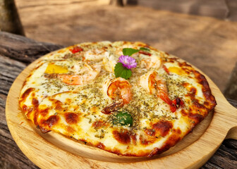 Delicious seafood cocktail pizza on the wooden plate.
