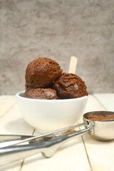 chocolate scoop ice cream in a bowl on a wooden table