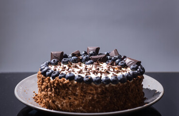 delicious chocolate cake with candles and blueberries for a holiday or birthday.