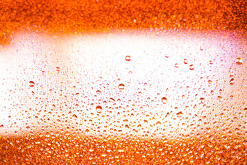 background texture for background bright orange, yellow, sunny color, peach color with shimmering elements and flowing drops on glass, beautiful bright background with overflows and gradient