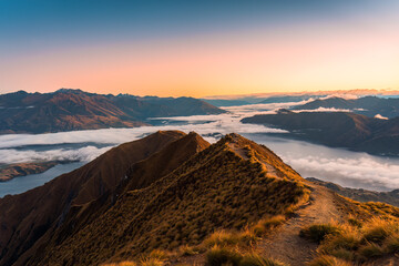 Sunrise shine over Roys Peak summit and foggy mountain over Lake Wanaka in autumn at New Zealand