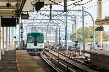 Electric railway train with metal structure and tracks arrival to station at Kyoto
