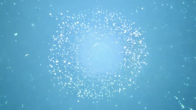 High-angle video captures an explosion of bioluminescent spores, a radiant burst of shimmering light, set against a clean, uniquely blurred pale blue background