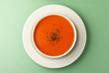 bowl of tomato soup with parsley on green background