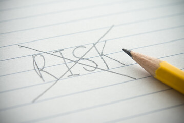 Close up pencil handwriting strikethrough RISK word on notepad background. Risk analysis, assessment and management in business, finance, investment and so on concept.