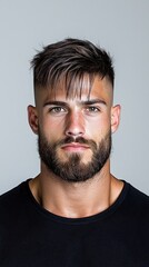 Fototapeta premium Confident Young Man with Stylish Hair and Beard Against Blank Background