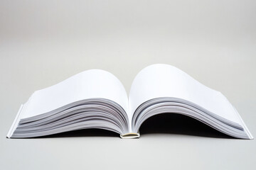 Obraz premium Blank open book with white pages on a neutral background, viewed from the center spine