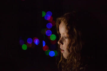 Young girl in low light with coloured lights