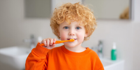 Child With Curly Hair Brushes Teeth in a Bright Bathroom During Morning Routine