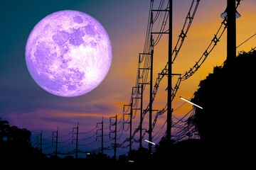 Surreal Landscape with Giant Purple Moon and Electric Poles at Sunset