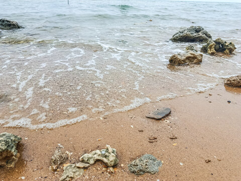 Tranquil Rocky Seaside with Overcast Sky and Gentle Waves