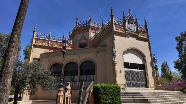 Majestic Costurero de la Reina in Maria Luisa Park, Seville, boasting ornate moorish revival architecture under a clear blue sky