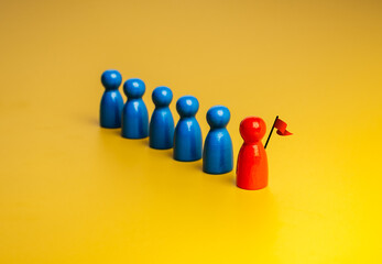 The red different one with flag, leader, leading blue peg dolls group, team symbol, on yellow background. Leadership, manager, unique, influencer, talent people, teamwork concept.