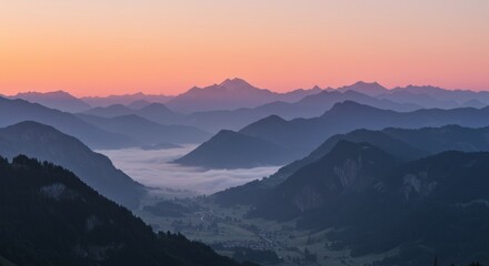 Fototapeta premium Mountain range landscape with fog in valleys at sunrise or sunset.