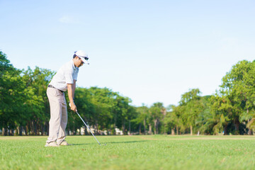 An Asian amateur golfer is enjoy playing golf in golf country club.