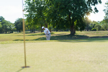 An Asian amateur golfer is enjoy playing golf in golf country club.