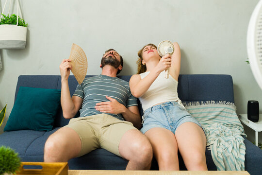 Overheated couple sweating at home during summer heat wave