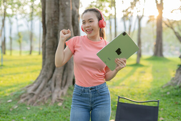 Woman uses iPad to listen to music outdoors